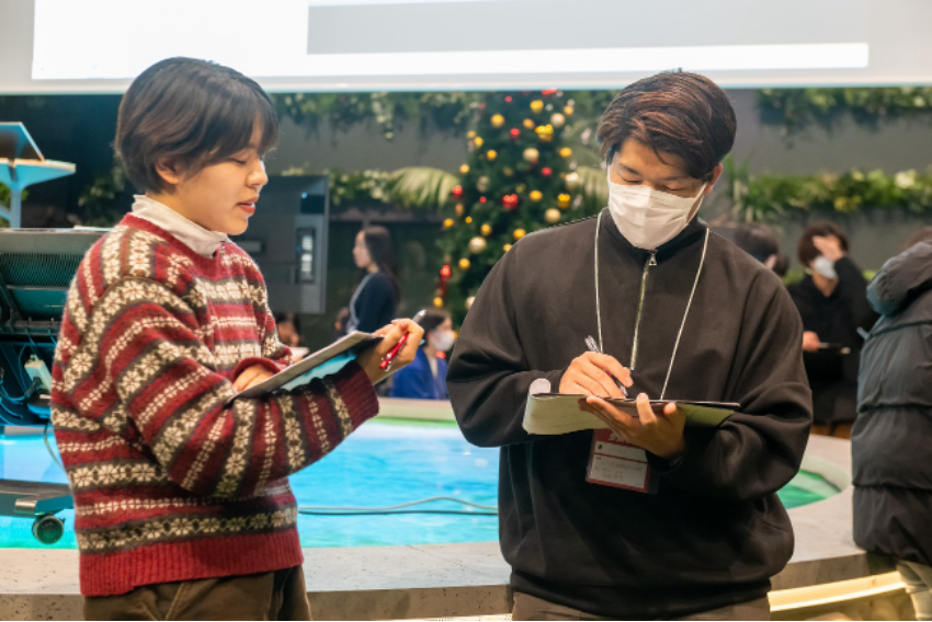 Phキャプション：大学4年時に参加した全国プログラムは対面で行われ、会場は全国から集まった学生たちの熱気にあふれていた